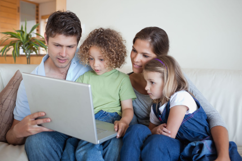 Attentive family viewing their laptop at home, London City Mortgages