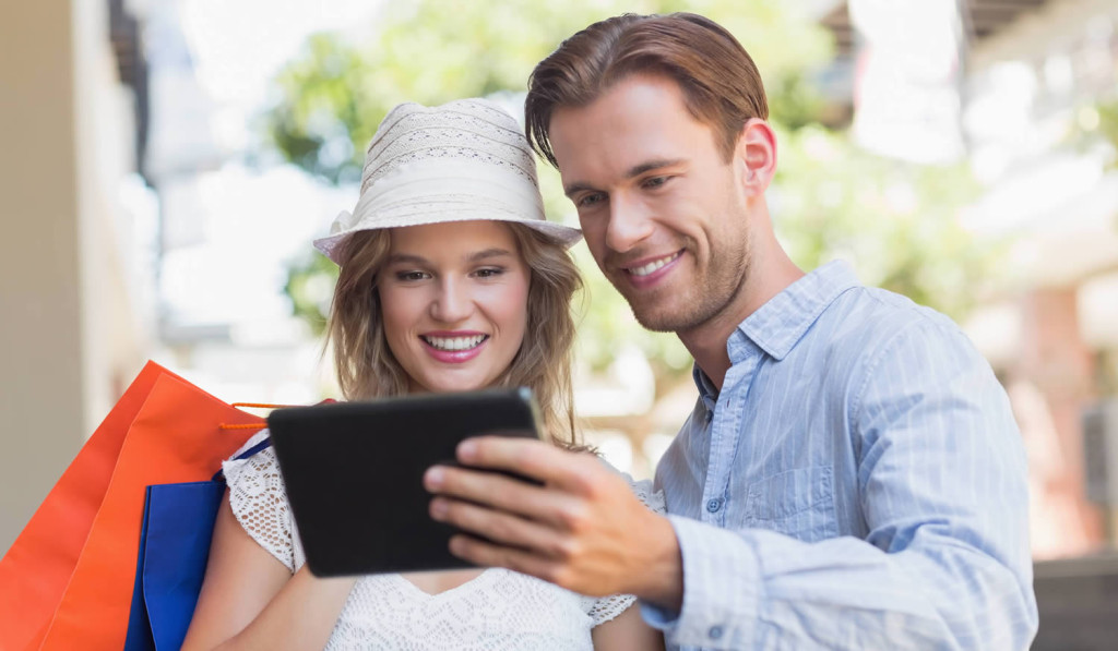 Attractive couple shopping and viewing their tablet updates, London City Mortgages