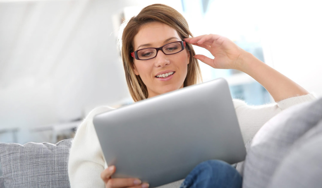 Attractive mature women relaxing at home reviewing her tablet results, London City Mortgages