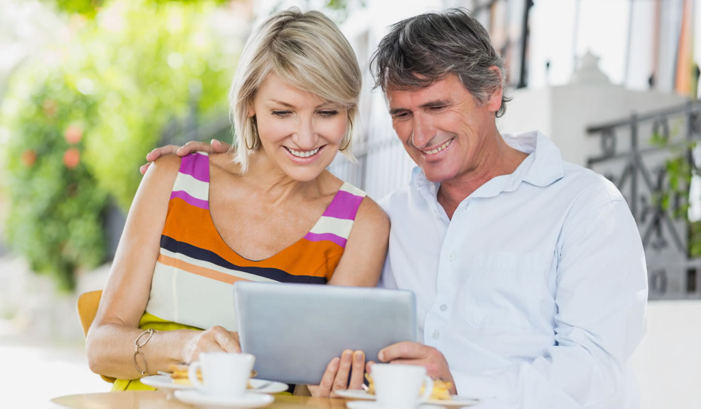 Couple having coffee viewing their tablet notices, London City Mortgages