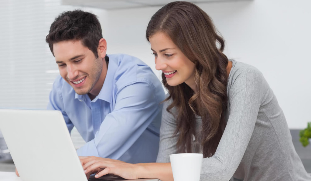 Couple in their kitchen viewing laptop news, London City Mortgages