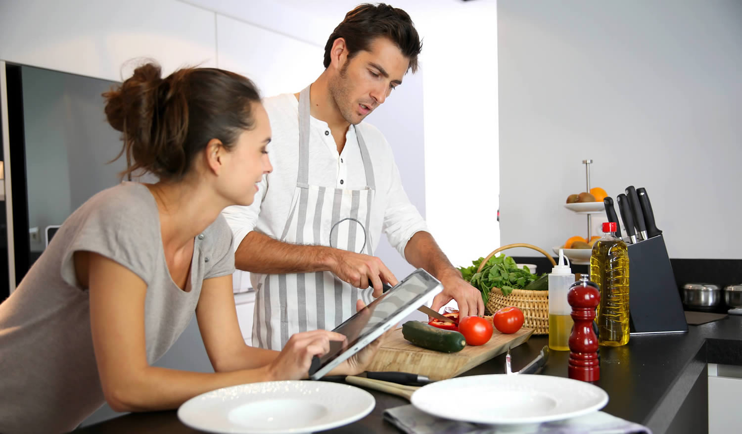Couple in the kitchen viewing their tablet results, London City Mortgages