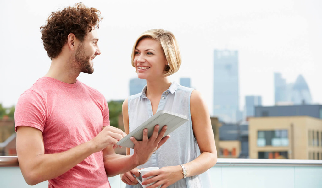 Couple on a roof terrace checking their tablet, London City Mortgages