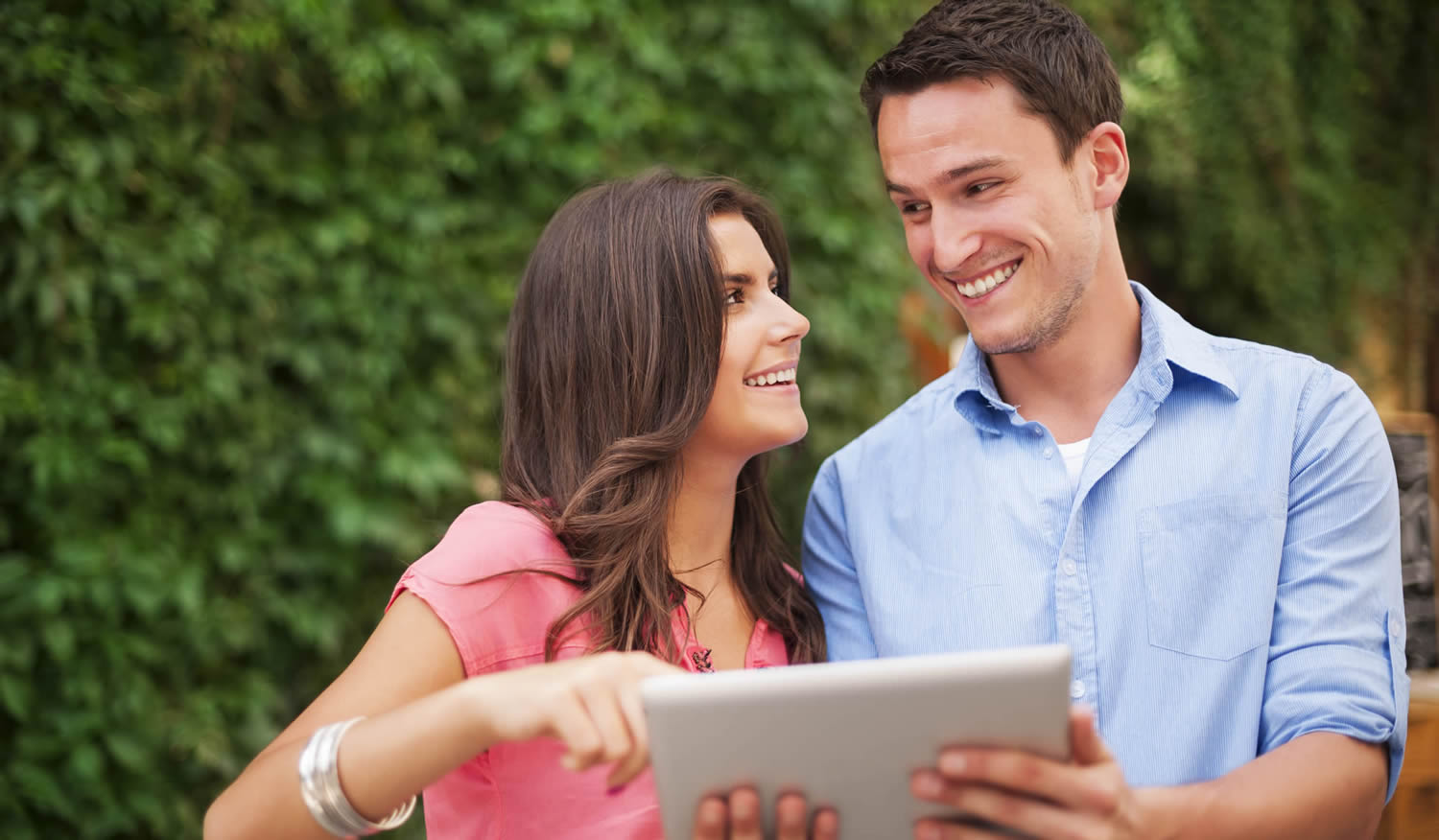 Couple outdoors while following updates on their tablet, London City Mortgages