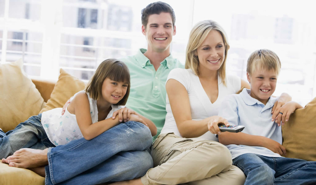 Family relaxing in their livingroom watching TV, London City Mortgages