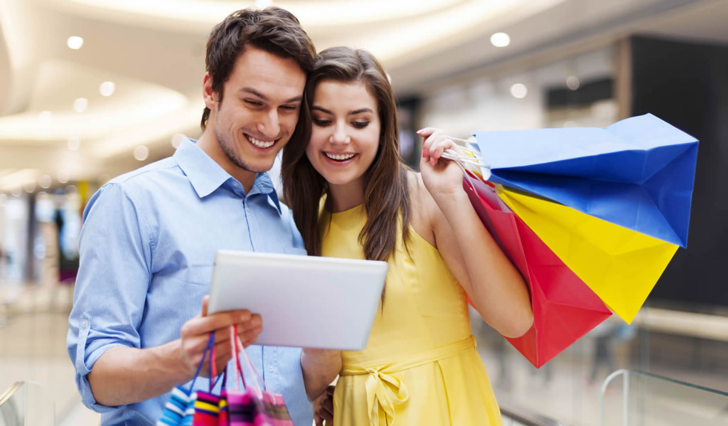 Happy couple using their tablet while shopping, London City Mortgage