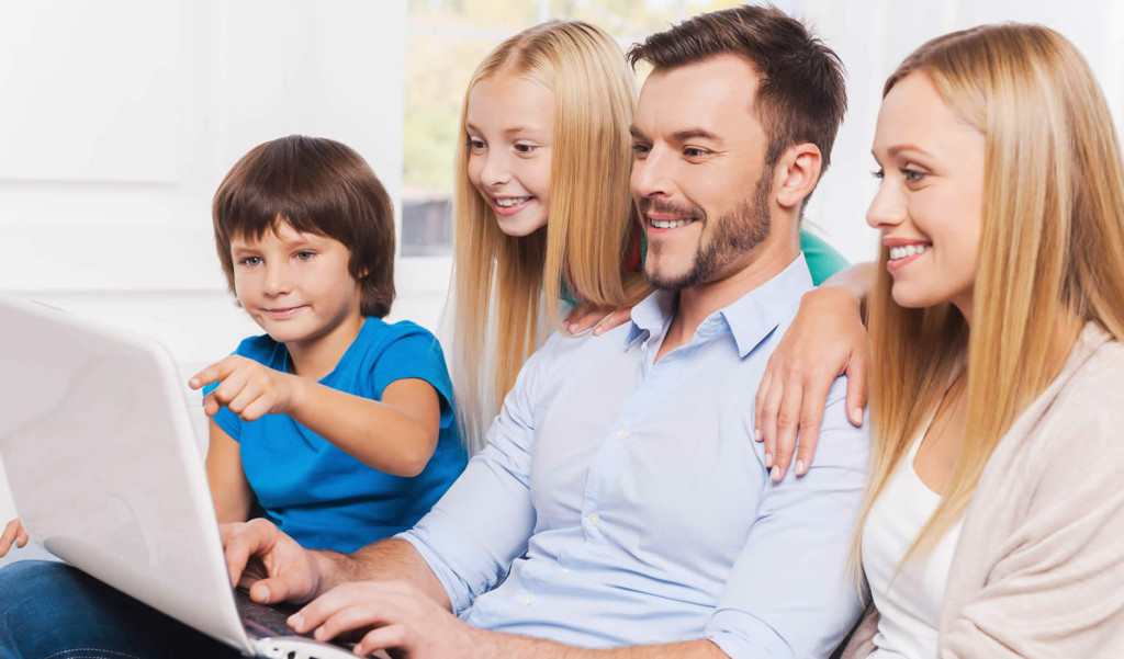 Happy family of four enjoying their laptop results, London City Mortgages