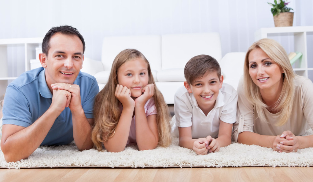 Happy family on the carpet enjoying their home, London City Mortgages