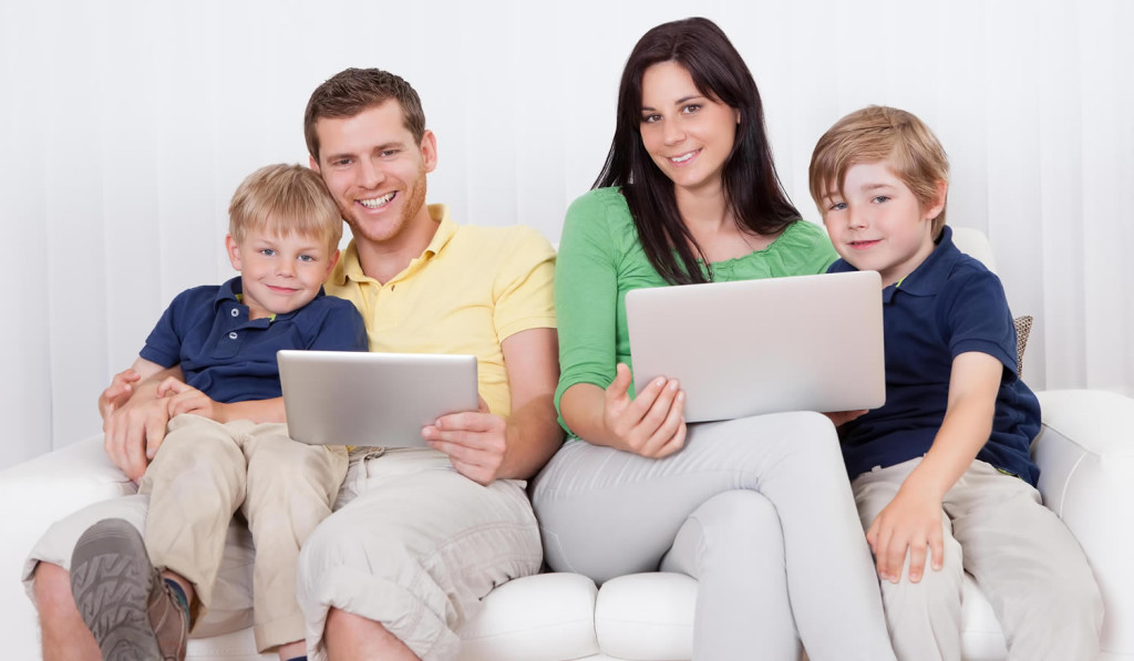 Happy family using their laptop and tablet at home, London City Mortgages