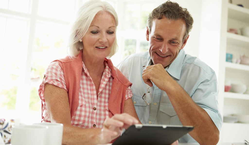 Middle aged couple looking at thier tablet results, London City Mortgages