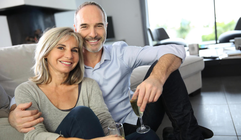 Older couple enjoying champagne in livingroom, London City Mortgages