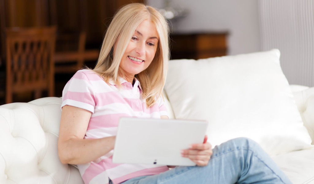 Older homeowner reviewing her tablet updates, London City Mortgages