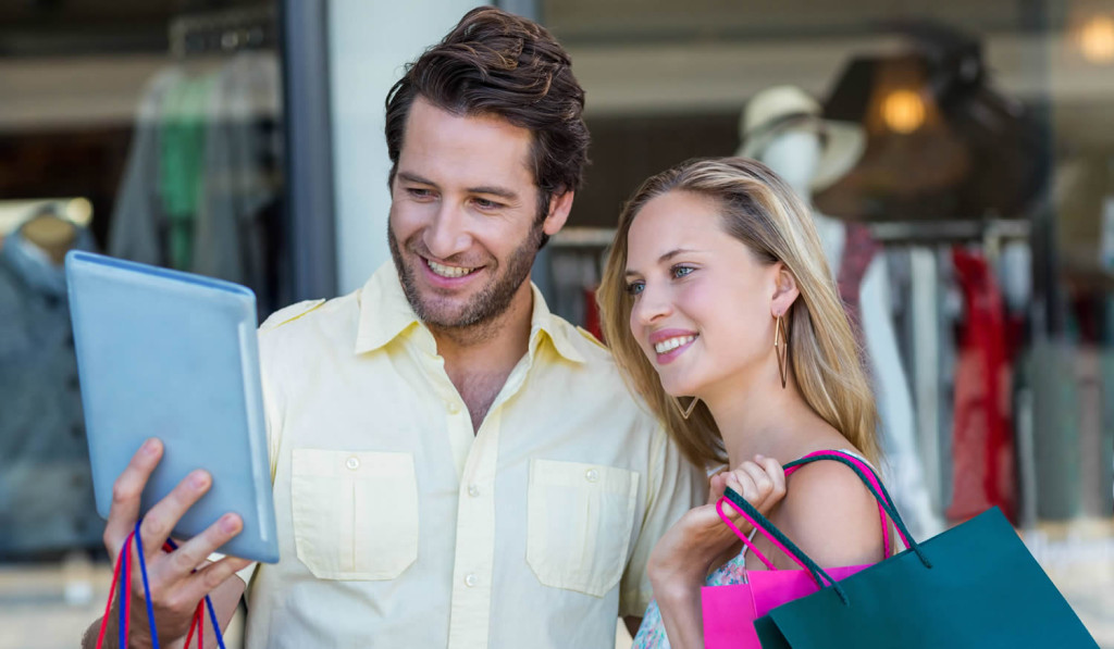 Smiling couple shopping and looking at updates on thier tablet results, London City Mortgages