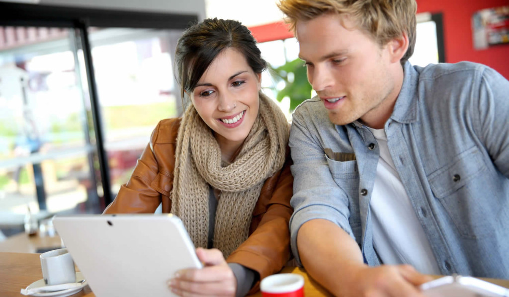 Young couple enjoying a coffee while engaging with thier tablet, London City Mortgages