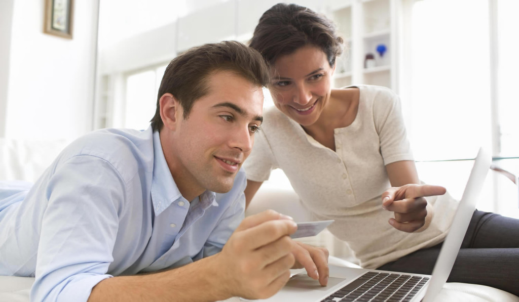 Young couple paying for advice online with their tablet, London City Mortgages