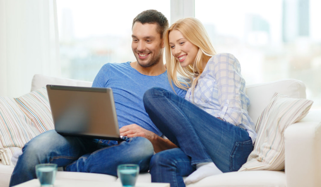 Apartment sofa couple reviewing laptop London City Mortgages