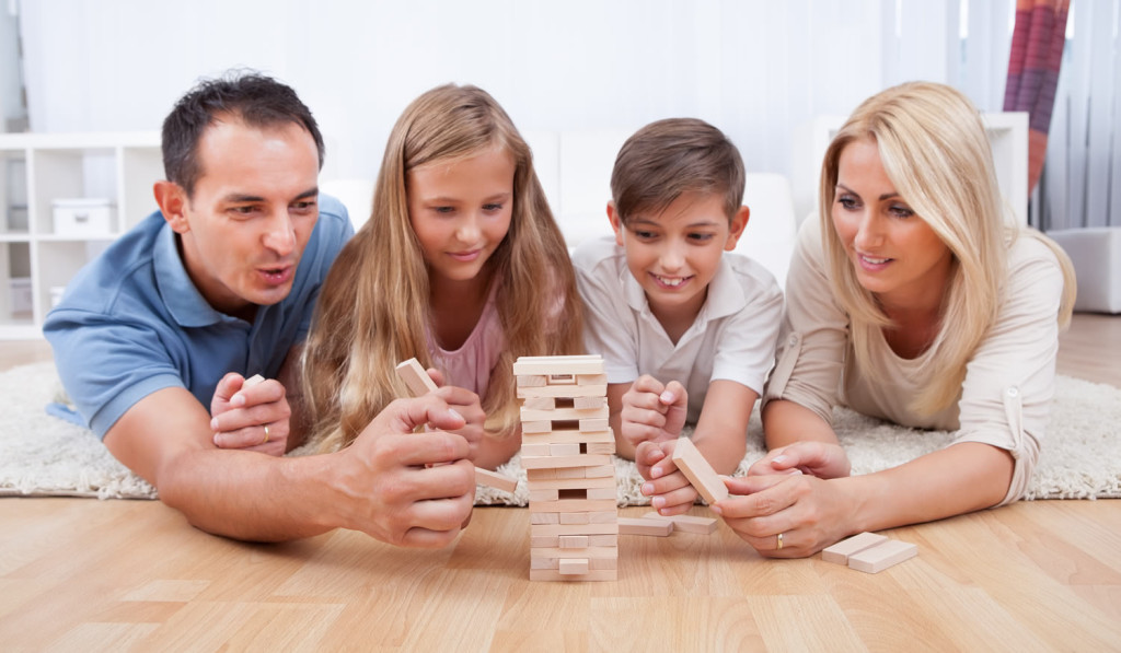 Family on livingroom floor playing jenga London City Mortgages