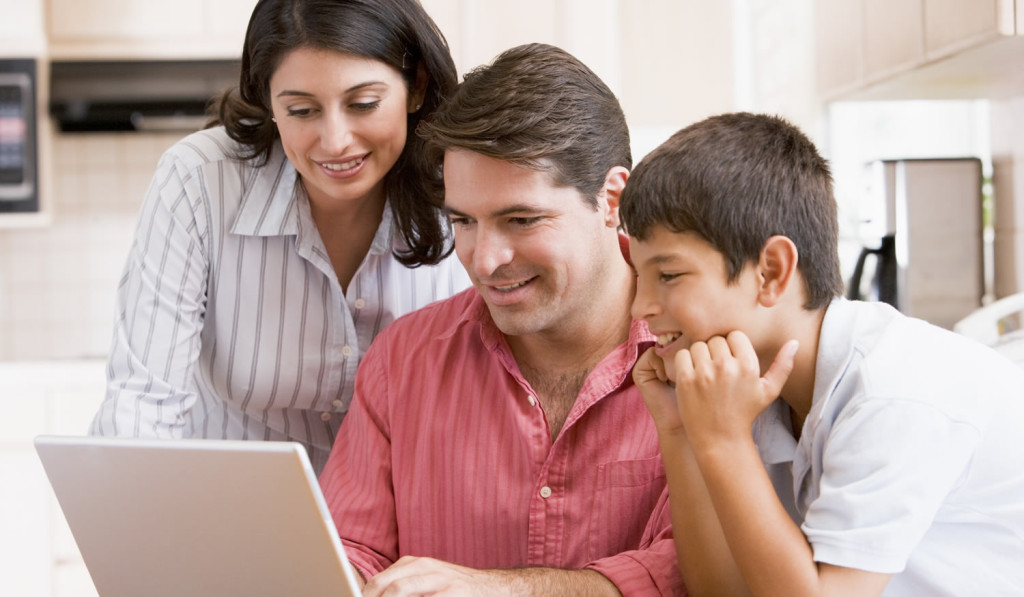 Kitchen with happy family accessing laptop London City Mortgages