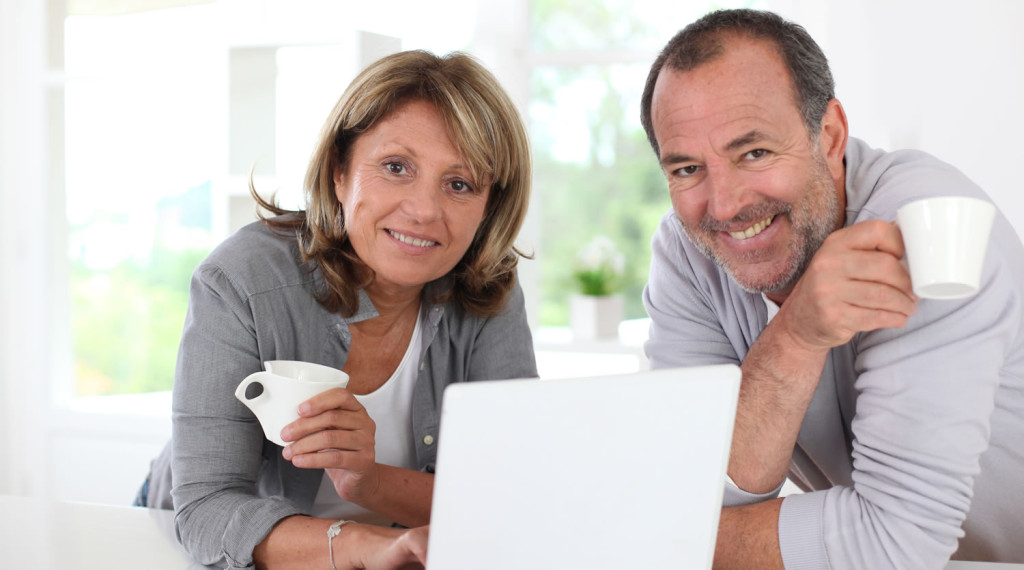 Mature couple enjoying coffee with laptop London City Mortgages