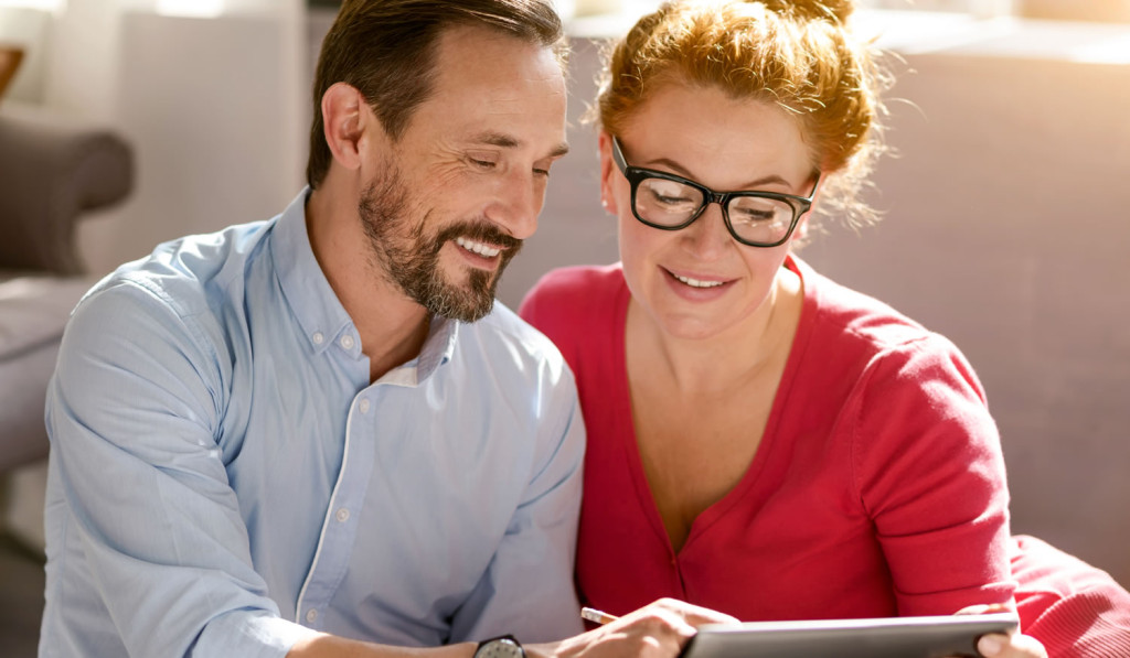 Middle age couple at home with laptop London City Mortgages