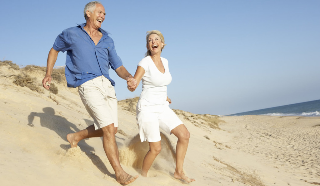 Older couple enjoying beach London City Mortgages