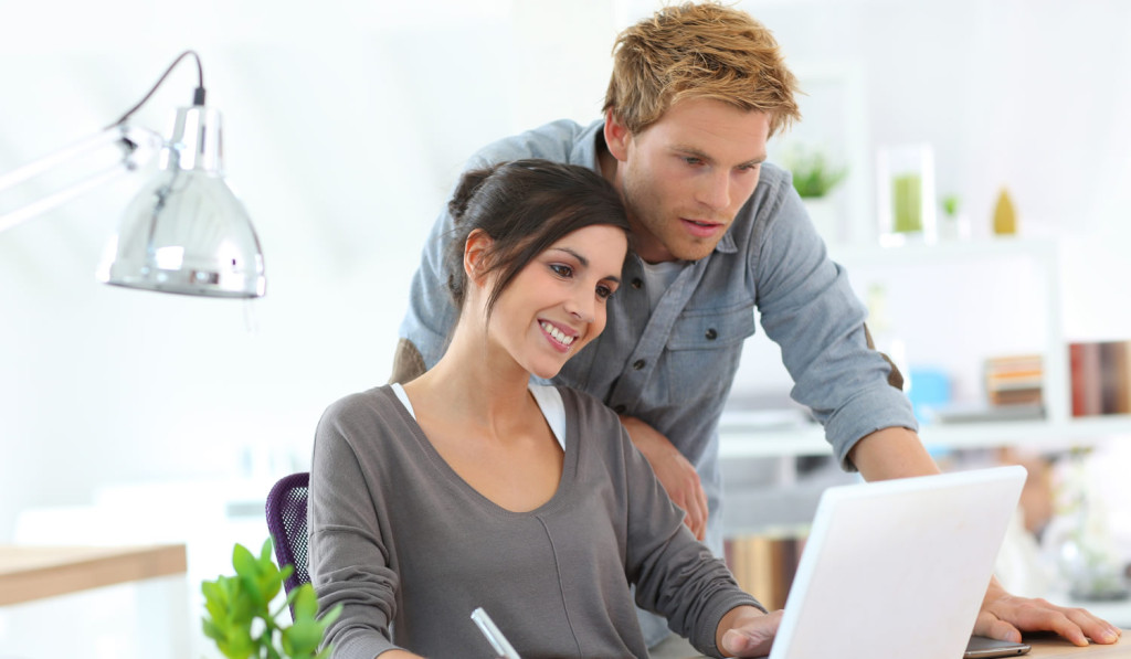 Pleased couple following laptop updates London City Mortgages