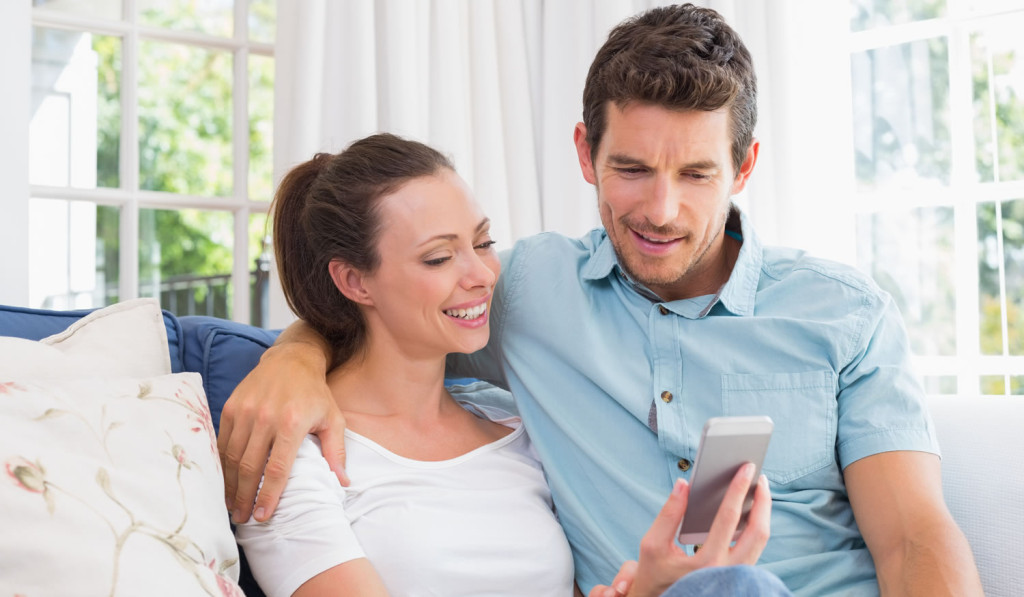 Summer house with couple smartphone-updates London City Mortgages