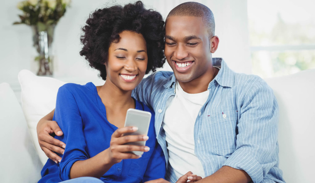 Young couple using smartphone apartment London City Mortgages